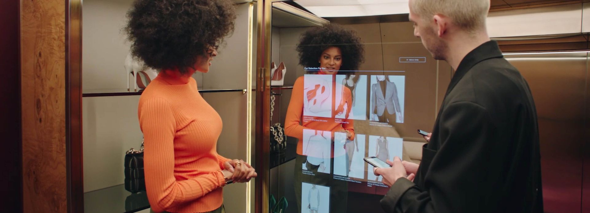 Female customer using digital mirror-screen device with male sales associate